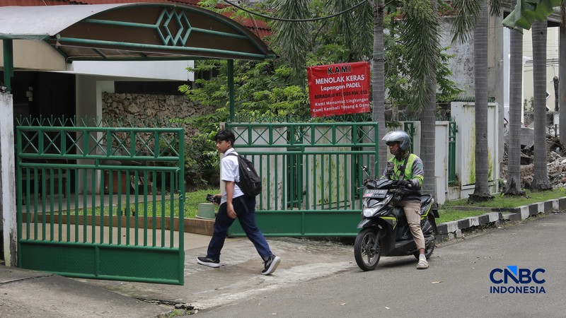 Deretan spanduk penolakan terbentang di pagar dan sudut jalan lingkungan RT 05/13, Pulomas, Jakarta Timur,  Selasa, (24/2/2026). (CNBC Indonesia/Muhammad Sabki)