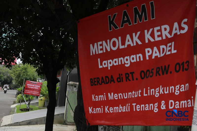 Deretan spanduk penolakan terbentang di pagar dan sudut jalan lingkungan RT 05/13, Pulomas, Jakarta Timur,  Selasa, (24/2/2026). (CNBC Indonesia/Muhammad Sabki)