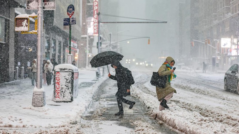 Seorang pejalan kaki berjalan di jalan saat salju turun selama badai musim dingin di Kota New York, AS, 23 Februari 2026. (REUTERS/Jeenah Moon)