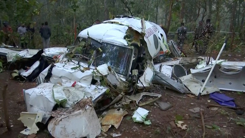 Polisi dan petugas keamanan bekerja di lokasi jatuhnya pesawat ambulans udara Beechcraft yang menewaskan ketujuh orang di dalamnya, di Chatra, India, Selasa (24/2/2026). (ANI/Reuters TV via REUTERS)