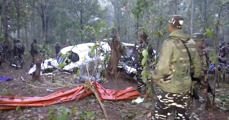 Polisi dan petugas keamanan bekerja di lokasi jatuhnya pesawat ambulans udara Beechcraft yang menewaskan ketujuh orang di dalamnya, di Chatra, India, Selasa (24/2/2026). (ANI/Reuters TV via REUTERS)