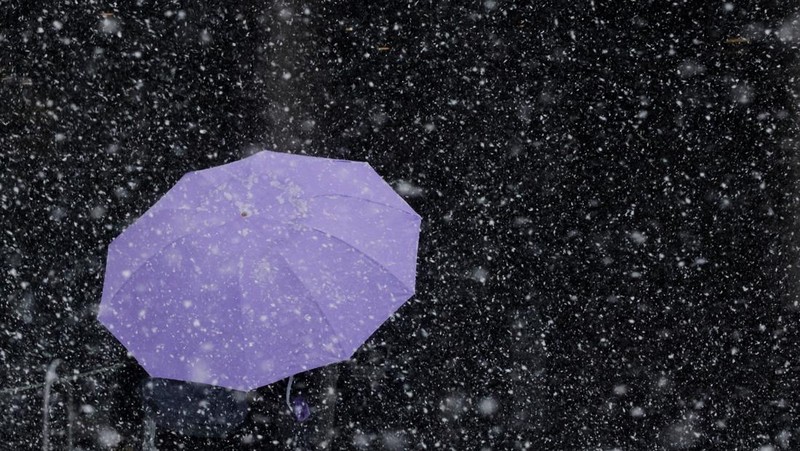 Seorang pejalan kaki berjalan di jalan saat salju turun selama badai musim dingin di Kota New York, AS, 23 Februari 2026. (REUTERS/Jeenah Moon)