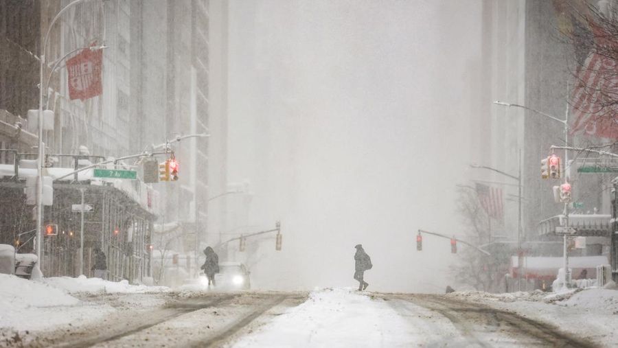 Seorang pejalan kaki berjalan di jalan saat salju turun selama badai musim dingin di Kota New York, AS, 23 Februari 2026. (REUTERS/Jeenah Moon)