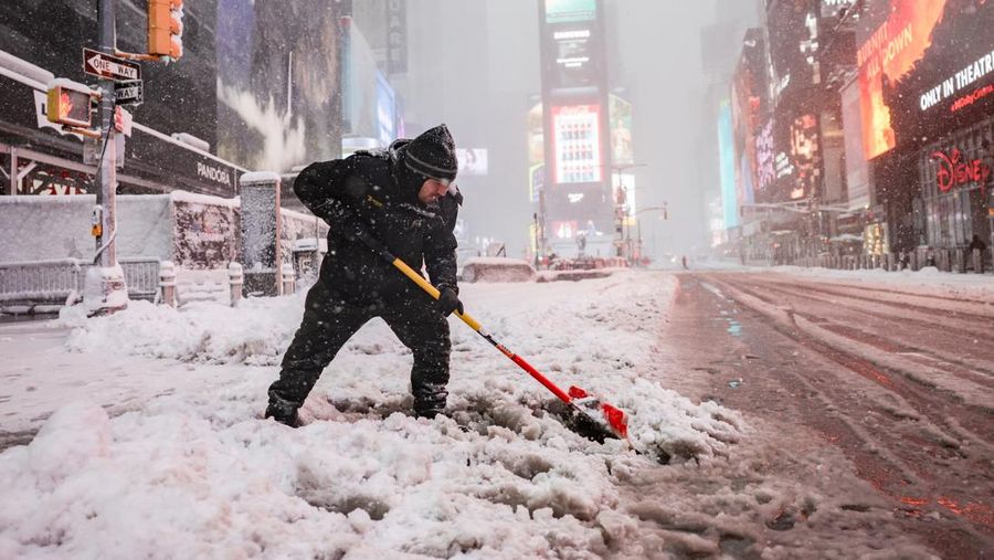 Seorang pejalan kaki berjalan di jalan saat salju turun selama badai musim dingin di Kota New York, AS, 23 Februari 2026. (REUTERS/Jeenah Moon)