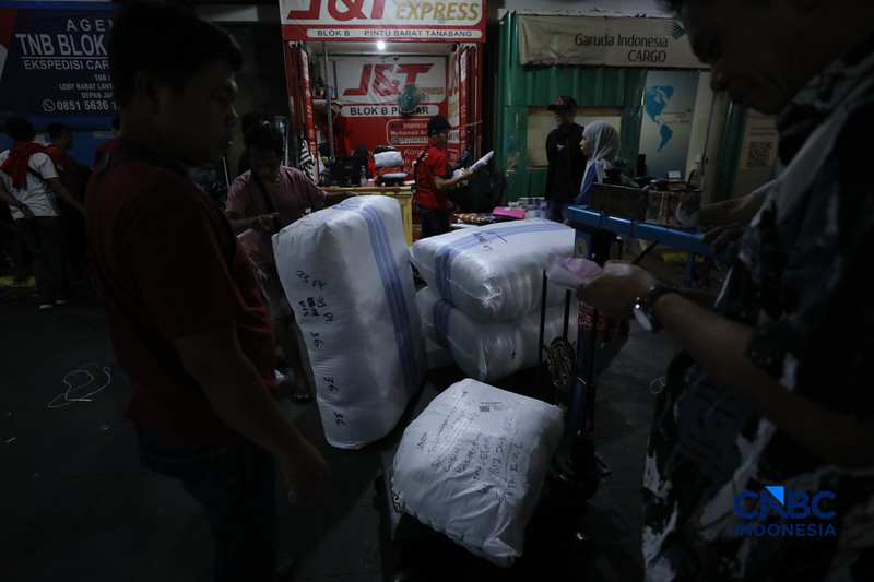 Karyawan menimbang barang yang akan dikirim ke luar pulau jawa di Pasar Tanah Abang, Jakarta, Rabu (25/2/2026). (CNBC Indonesia/Tri Susilo)