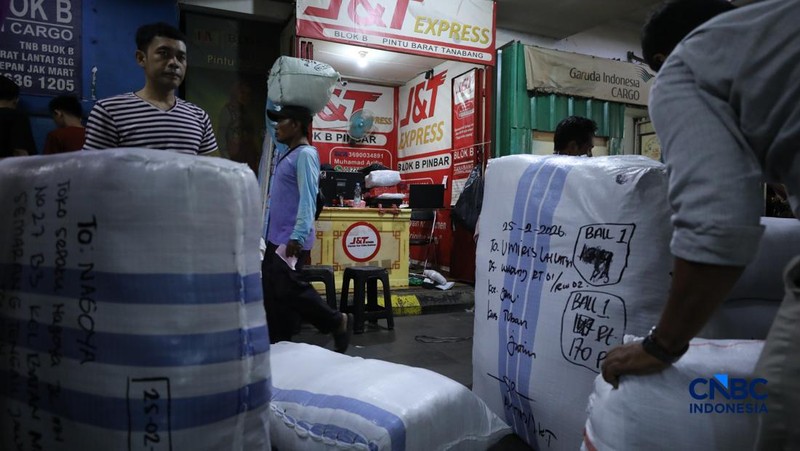 Karyawan menimbang barang yang akan dikirim ke luar pulau jawa di Pasar Tanah Abang, Jakarta, Rabu (25/2/2026). (CNBC Indonesia/Tri Susilo)