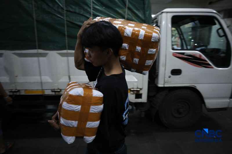 Karyawan menimbang barang yang akan dikirim ke luar pulau jawa di Pasar Tanah Abang, Jakarta, Rabu (25/2/2026). (CNBC Indonesia/Tri Susilo)