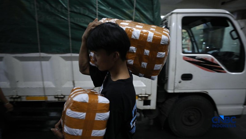 Karyawan menimbang barang yang akan dikirim ke luar pulau jawa di Pasar Tanah Abang, Jakarta, Rabu (25/2/2026). (CNBC Indonesia/Tri Susilo)