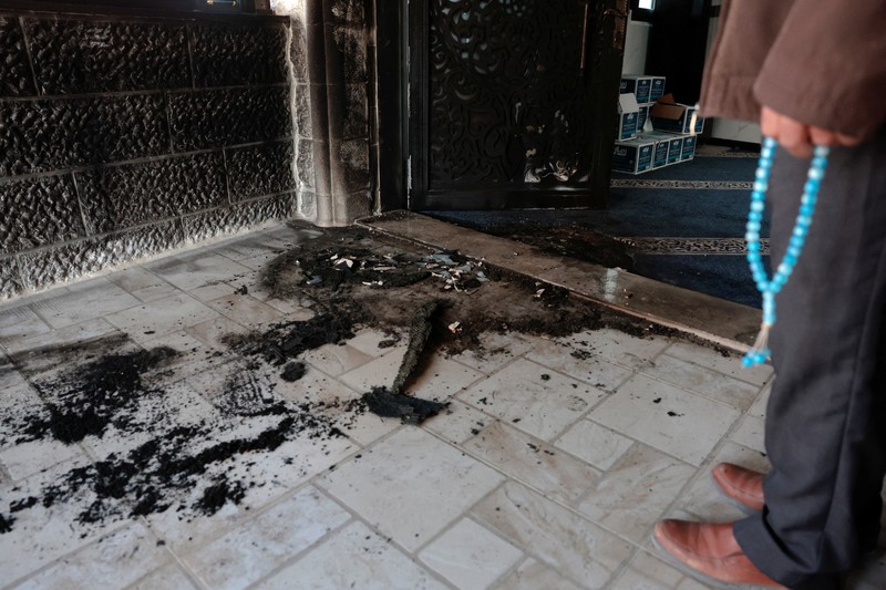 Puing-puing di pintu masuk sebuah masjid, yang menurut warga Palestina dirusak oleh pemukim Israel, di desa Surra, Tepi Barat, dekat Nablus di Tepi Barat yang diduduki Israel, Senin (23/2/2026). (REUTERS/Mohamad Torokman)