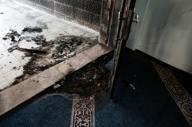 Puing-puing di pintu masuk sebuah masjid, yang menurut warga Palestina dirusak oleh pemukim Israel, di desa Surra, Tepi Barat, dekat Nablus di Tepi Barat yang diduduki Israel, Senin (23/2/2026). (REUTERS/Mohamad Torokman)