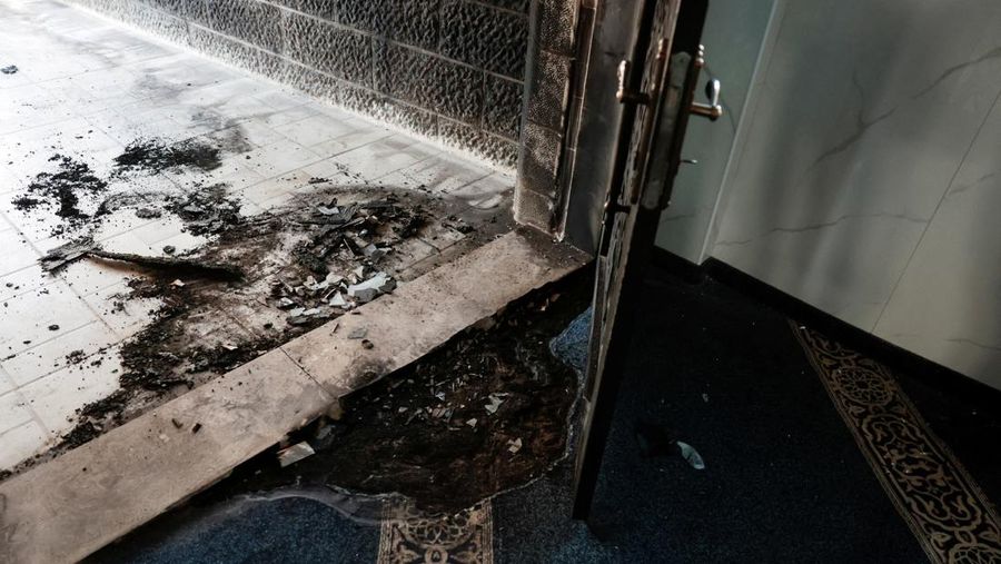 Puing-puing di pintu masuk sebuah masjid, yang menurut warga Palestina dirusak oleh pemukim Israel, di desa Surra, Tepi Barat, dekat Nablus di Tepi Barat yang diduduki Israel, Senin (23/2/2026). (REUTERS/Mohamad Torokman)