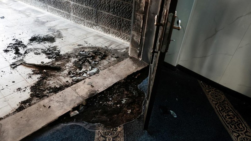 Puing-puing di pintu masuk sebuah masjid, yang menurut warga Palestina dirusak oleh pemukim Israel, di desa Surra, Tepi Barat, dekat Nablus di Tepi Barat yang diduduki Israel, Senin (23/2/2026). (REUTERS/Mohamad Torokman)