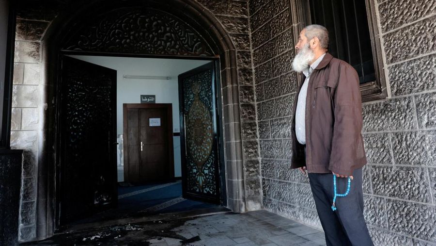 Puing-puing di pintu masuk sebuah masjid, yang menurut warga Palestina dirusak oleh pemukim Israel, di desa Surra, Tepi Barat, dekat Nablus di Tepi Barat yang diduduki Israel, Senin (23/2/2026). (REUTERS/Mohamad Torokman)