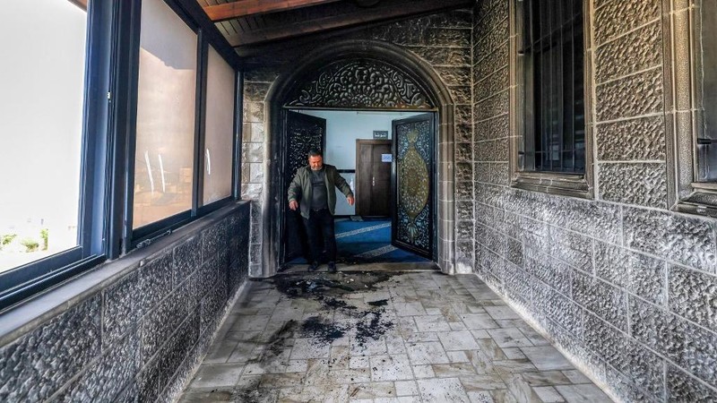 Puing-puing di pintu masuk sebuah masjid, yang menurut warga Palestina dirusak oleh pemukim Israel, di desa Surra, Tepi Barat, dekat Nablus di Tepi Barat yang diduduki Israel, Senin (23/2/2026). (REUTERS/Mohamad Torokman)