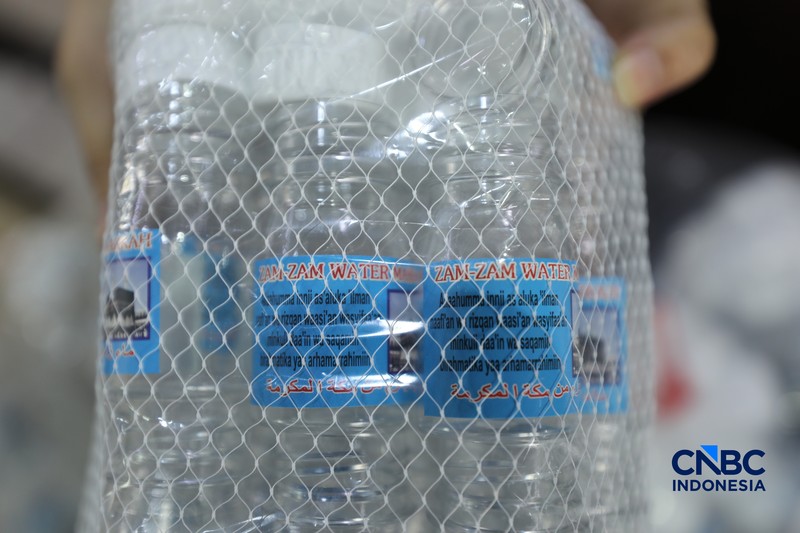 Seorang karyawan menujukkan Air Zamzam yang dijual di toko kawasan Pasar Tanah Abang, Jakarta, Rabu (25/2/2026). (CNBC Indonesia/Tri Susilo)