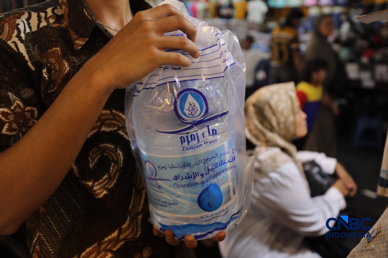 Seorang karyawan menujukkan Air Zamzam yang dijual di toko kawasan Pasar Tanah Abang, Jakarta, Rabu (25/2/2026). (CNBC Indonesia/Tri Susilo)