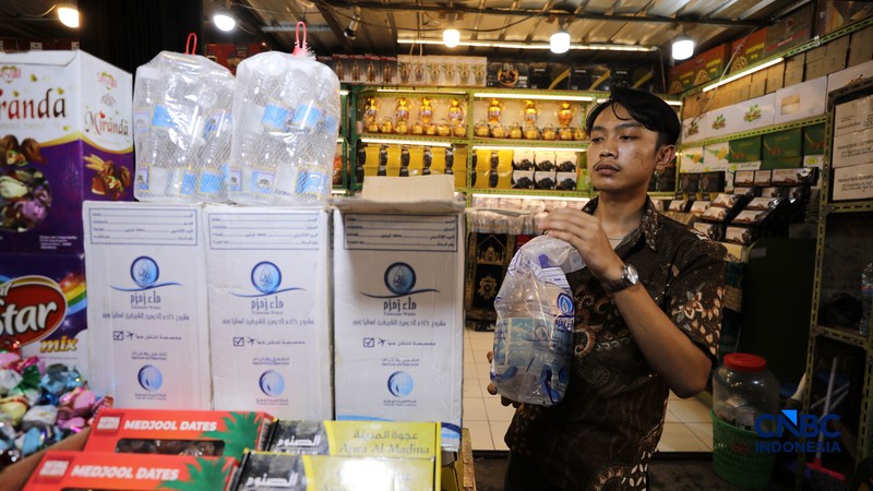 Seorang karyawan menujukkan Air Zamzam yang dijual di toko kawasan Pasar Tanah Abang, Jakarta, Rabu (25/2/2026). (CNBC Indonesia/Tri Susilo)