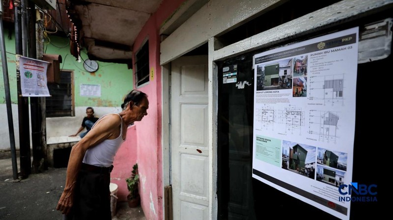 Warga menujukkan desain rumah yang tertera di halaman rumahnya, Kamis (26/2/2026). (CNBC Indonesia/Tri Susilo)