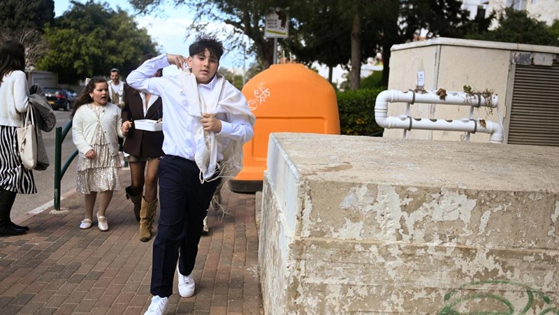 Warga Israel memasuki tempat perlindungan bawah tanah setelah militer Israel mengumumkan telah mengidentifikasi rudal yang diluncurkan dari Iran ke arah Israel, di Haifa, Israel utara, Sabtu (28/2/2026.(REUTERS/Rami Shlush)