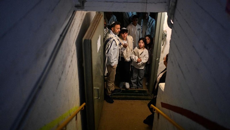 Warga Israel memasuki tempat perlindungan bawah tanah setelah militer Israel mengumumkan telah mengidentifikasi rudal yang diluncurkan dari Iran ke arah Israel, di Haifa, Israel utara, Sabtu (28/2/2026.(REUTERS/Rami Shlush)
