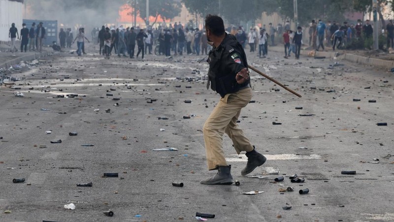 Aksi demonstrasi merespons serangan AS dan Israel di tembok luar konsulat AS di Karachi, Pakistan, Minggu (1/3/2026). (REUTERS/Akhtar Soomro)