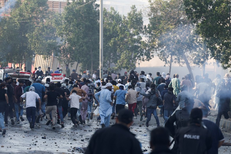 Aksi demonstrasi merespons serangan AS dan Israel di tembok luar konsulat AS di Karachi, Pakistan, Minggu (1/3/2026). (REUTERS/Akhtar Soomro)