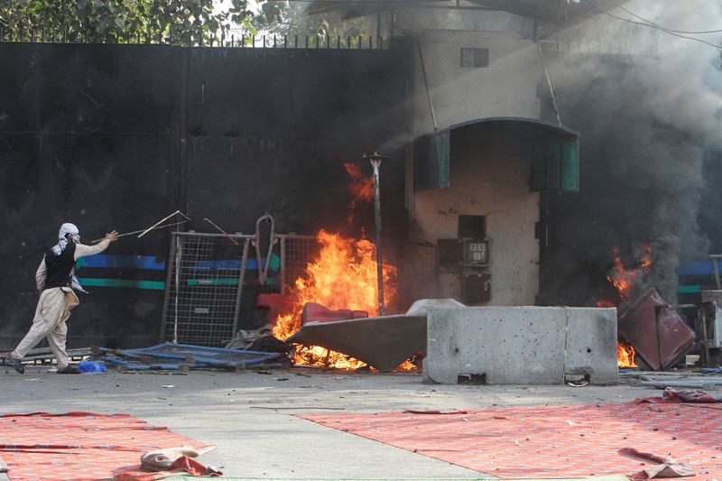 Aksi demonstrasi merespons serangan AS dan Israel di tembok luar konsulat AS di Karachi, Pakistan, Minggu (1/3/2026). (REUTERS/Akhtar Soomro)