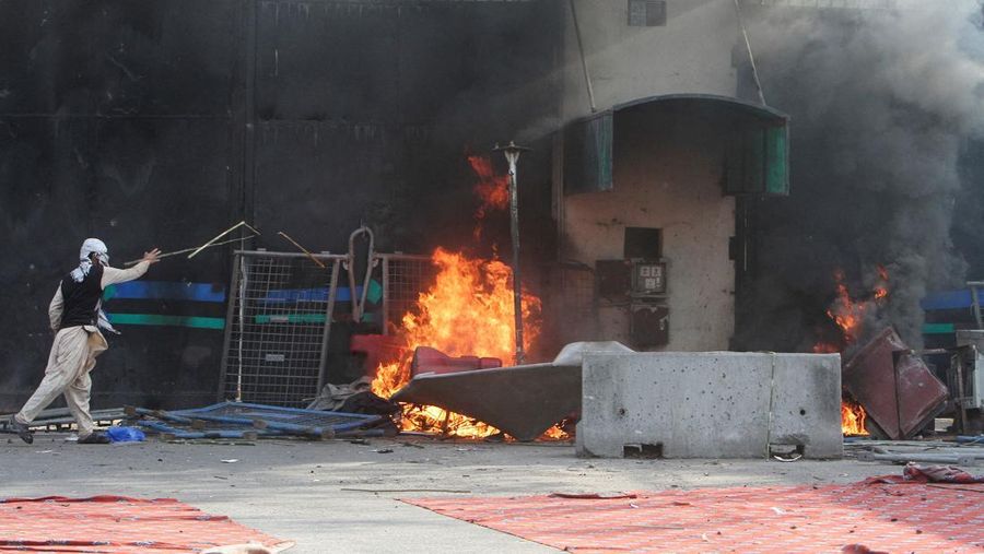 Aksi demonstrasi merespons serangan AS dan Israel di tembok luar konsulat AS di Karachi, Pakistan, Minggu (1/3/2026). (REUTERS/Akhtar Soomro)