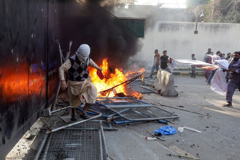 Aksi demonstrasi merespons serangan AS dan Israel di tembok luar konsulat AS di Karachi, Pakistan, Minggu (1/3/2026). (REUTERS/Akhtar Soomro)