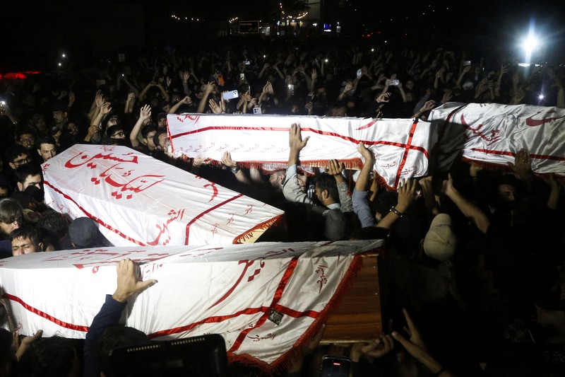 Orang-orang membawa peti mati para korban yang tewas setelah menerobos tembok luar Konsulat Jenderal AS selama protes menyusul berita serangan AS dan Israel terhadap Iran yang menewaskan mendiang Pemimpin Tertinggi Iran Ayatollah Ali Khamenei, selama pemakaman mereka di Karachi, Pakistan, 1 Maret 2026. REUTERS/Shakil Adil