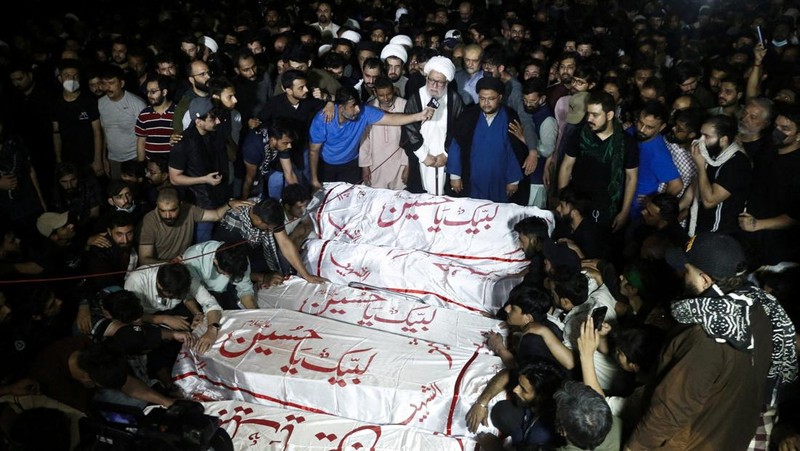 Orang-orang membawa peti mati para korban yang tewas setelah menerobos tembok luar Konsulat Jenderal AS selama protes menyusul berita serangan AS dan Israel terhadap Iran yang menewaskan mendiang Pemimpin Tertinggi Iran Ayatollah Ali Khamenei, selama pemakaman mereka di Karachi, Pakistan, 1 Maret 2026. REUTERS/Shakil Adil