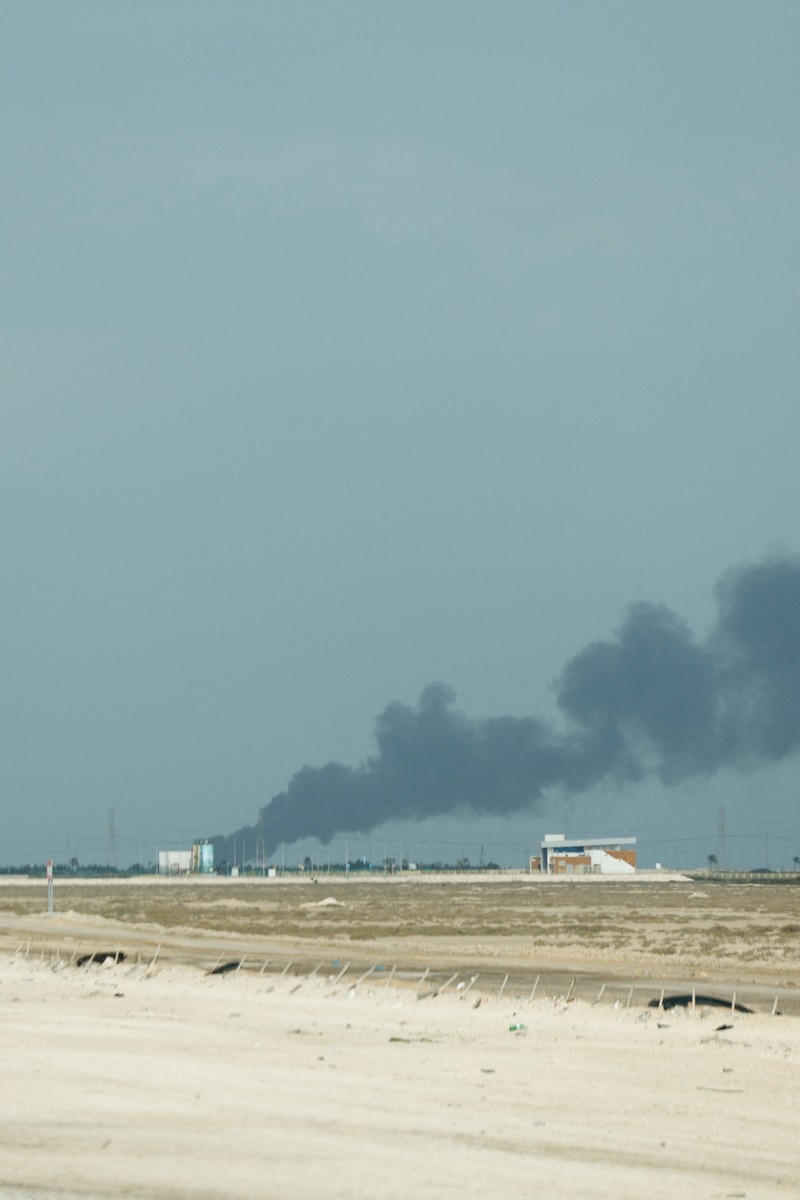 Workers evacuate area around Saudi Aramco's Ras Tanura oil refinery as smoke rises following a reported Iranian drone strike, in Ras Tanura, Saudi Arabia, in this still image obtained from social media video released on March 2, 2026. Social Media/via REUTERS  THIS IMAGE HAS BEEN SUPPLIED BY A THIRD PARTY. NO RESALES. NO ARCHIVES. NEWS USE ONLY. VERIFICATION: Reuters verified the location from the buildings, trees and the smoke stacks seen in the video, which matched satellite imagery of the area. The date was verified from an official statement from Aramco saying it had shut the facility down after a drone strike on March 2. No older versions of the videos were found posted online before March 2. Coordinates: 26.70322602981727, 50.090750650948635.