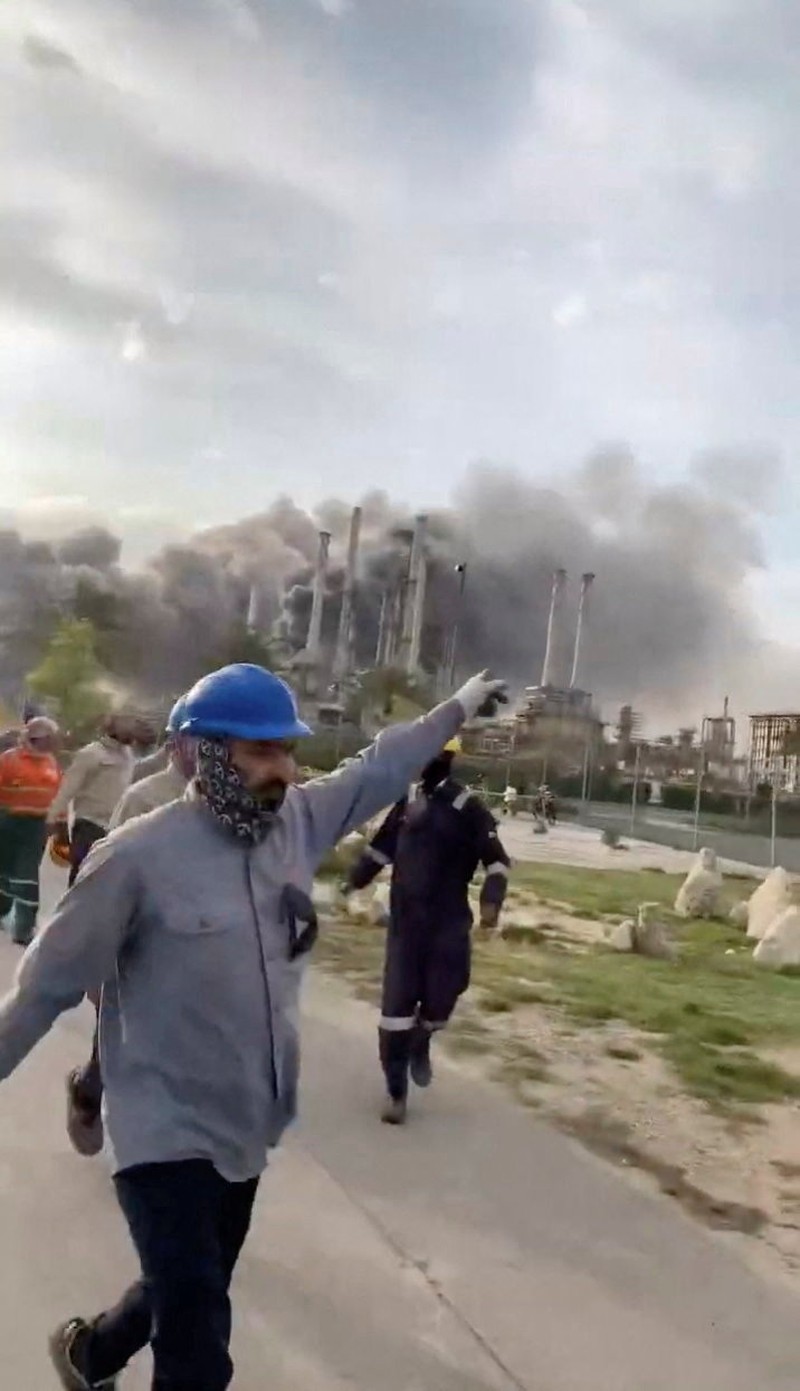 Workers evacuate area around Saudi Aramco's Ras Tanura oil refinery as smoke rises following a reported Iranian drone strike, in Ras Tanura, Saudi Arabia, in this still image obtained from social media video released on March 2, 2026. Social Media/via REUTERS  THIS IMAGE HAS BEEN SUPPLIED BY A THIRD PARTY. NO RESALES. NO ARCHIVES. NEWS USE ONLY. VERIFICATION: Reuters verified the location from the buildings, trees and the smoke stacks seen in the video, which matched satellite imagery of the area. The date was verified from an official statement from Aramco saying it had shut the facility down after a drone strike on March 2. No older versions of the videos were found posted online before March 2. Coordinates: 26.70322602981727, 50.090750650948635.