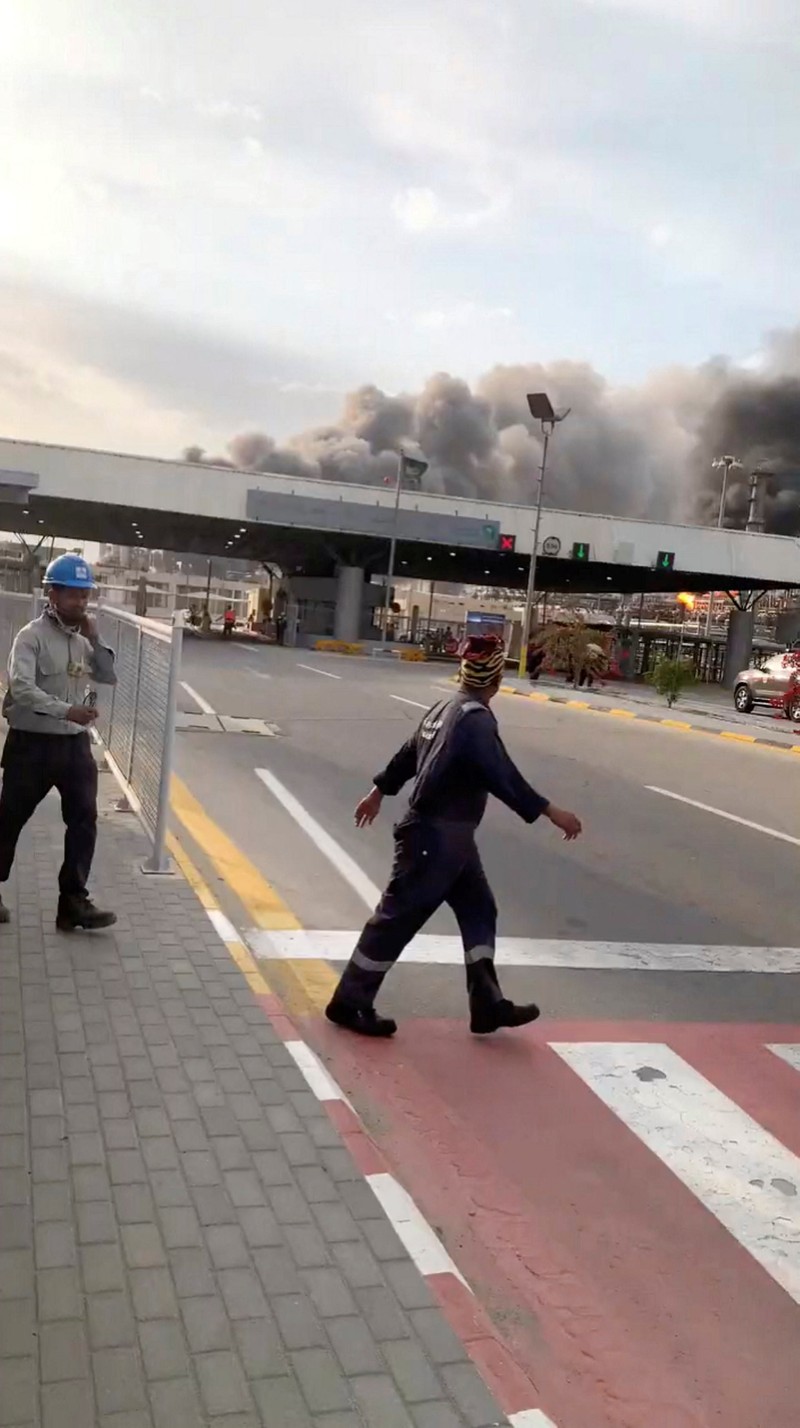 Workers evacuate area around Saudi Aramco's Ras Tanura oil refinery as smoke rises following a reported Iranian drone strike, in Ras Tanura, Saudi Arabia, in this still image obtained from social media video released on March 2, 2026. Social Media/via REUTERS  THIS IMAGE HAS BEEN SUPPLIED BY A THIRD PARTY. NO RESALES. NO ARCHIVES. NEWS USE ONLY. VERIFICATION: Reuters verified the location from the buildings, trees and the smoke stacks seen in the video, which matched satellite imagery of the area. The date was verified from an official statement from Aramco saying it had shut the facility down after a drone strike on March 2. No older versions of the videos were found posted online before March 2. Coordinates: 26.70322602981727, 50.090750650948635.