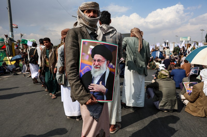 Ribuan orang membawa poster bergambar mendiang Pemimpin Tertinggi Iran, Ayatollah Ali Khamenei, saat menggelar aksi unjuk rasa menentang serangan Israel dan Amerika Serikat terhadap Iran di Sanaa, Yaman, Minggu (1/3/2026). Aksi tersebut berlangsung di tengah meningkatnya ketegangan kawasan menyusul kabar pembunuhan pemimpin tertinggi Iran itu. (REUTERS/Khaled Abdullah)