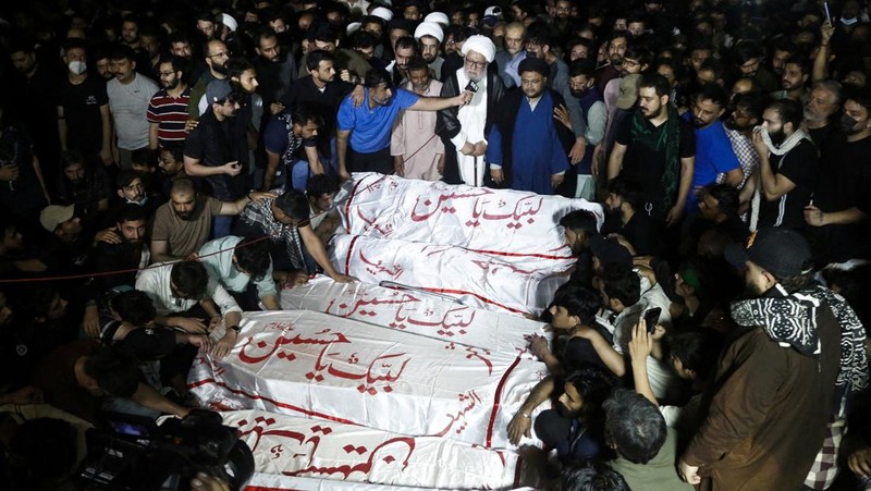 Aksi demonstrasi merespons serangan AS dan Israel di tembok luar konsulat AS di Karachi, Pakistan, Minggu (1/3/2026). (REUTERS/Akhtar Soomro)