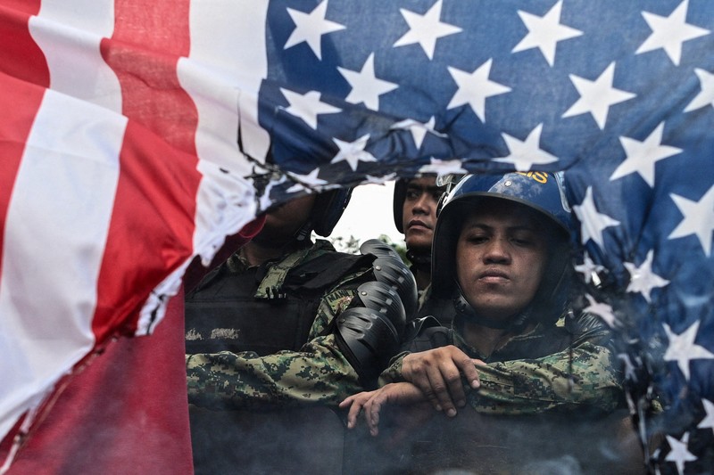 Para pengunjuk rasa membakar bendera AS selama demonstrasi menentang serangan AS-Israel terhadap Iran, di tengah konflik dengan Iran, di dekat Kedutaan Besar AS di Manila, Filipina, 3 Maret 2026. (REUTERS/Noel Celis)