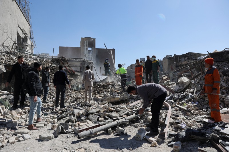 Sebuah kantor polisi di Teheran hampir hancur total akibat serangan udara yang mengguncang ibu kota Iran pada Senin (2/3). Bangunan tersebut luluh lantak, dengan puing-puing berserakan di jalan-jalan sekitar lokasi kejadian. (Tangkapan Layar Video Reuters/WANA)