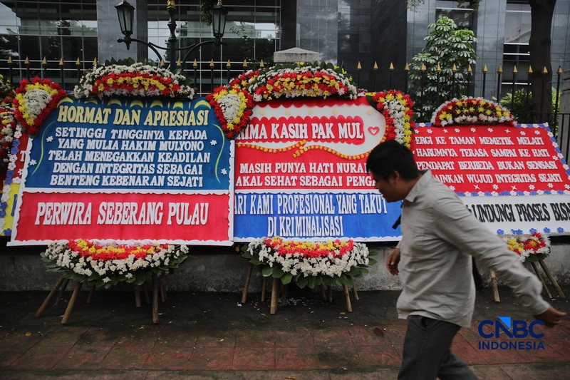 Warga berjalan di dekat deretan karangan bunga dukungan untuk Hakim anggota Mulyono di depan Pengadilan Tipikor, Jakarta, Rabu (4/3/2026). (CNBC Indonesia/Faisal Rahman)