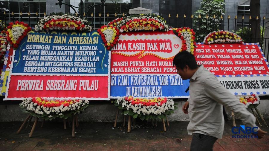 Warga berjalan di dekat deretan karangan bunga dukungan untuk Hakim anggota Mulyono di depan Pengadilan Tipikor, Jakarta, Rabu (4/3/2026). (CNBC Indonesia/Faisal Rahman)