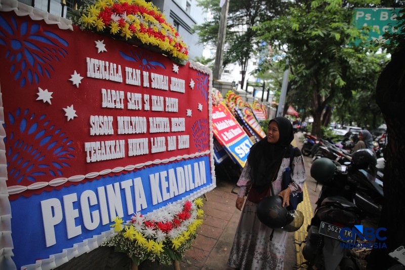 Warga berjalan di dekat deretan karangan bunga dukungan untuk Hakim anggota Mulyono di depan Pengadilan Tipikor, Jakarta, Rabu (4/3/2026). (CNBC Indonesia/Faisal Rahman)