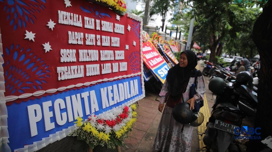 Warga berjalan di dekat deretan karangan bunga dukungan untuk Hakim anggota Mulyono di depan Pengadilan Tipikor, Jakarta, Rabu (4/3/2026). (CNBC Indonesia/Faisal Rahman)