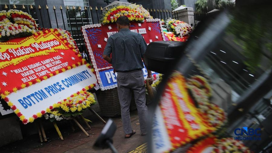 Warga berjalan di dekat deretan karangan bunga dukungan untuk Hakim anggota Mulyono di depan Pengadilan Tipikor, Jakarta, Rabu (4/3/2026). (CNBC Indonesia/Faisal Rahman)