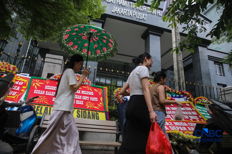 Warga berjalan di dekat deretan karangan bunga dukungan untuk Hakim anggota Mulyono di depan Pengadilan Tipikor, Jakarta, Rabu (4/3/2026). (CNBC Indonesia/Faisal Rahman)