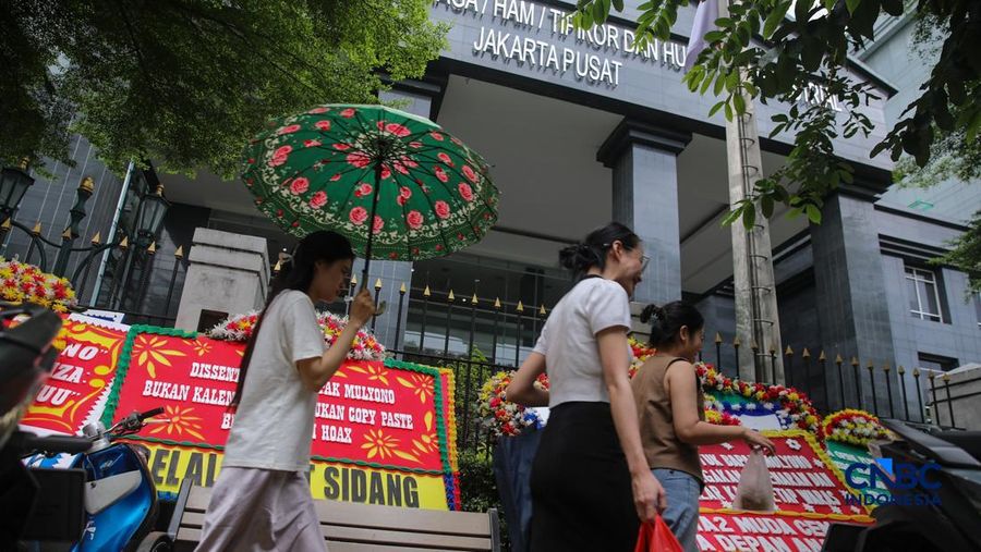 Warga berjalan di dekat deretan karangan bunga dukungan untuk Hakim anggota Mulyono di depan Pengadilan Tipikor, Jakarta, Rabu (4/3/2026). (CNBC Indonesia/Faisal Rahman)