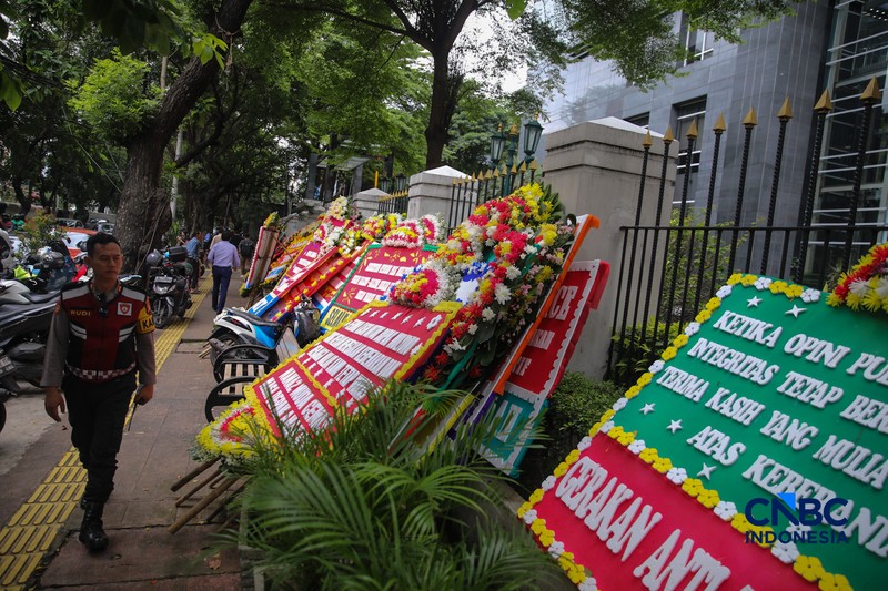 Warga berjalan di dekat deretan karangan bunga dukungan untuk Hakim anggota Mulyono di depan Pengadilan Tipikor, Jakarta, Rabu (4/3/2026). (CNBC Indonesia/Faisal Rahman)