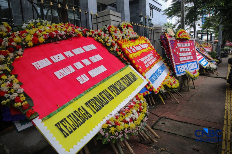 Warga berjalan di dekat deretan karangan bunga dukungan untuk Hakim anggota Mulyono di depan Pengadilan Tipikor, Jakarta, Rabu (4/3/2026). (CNBC Indonesia/Faisal Rahman)