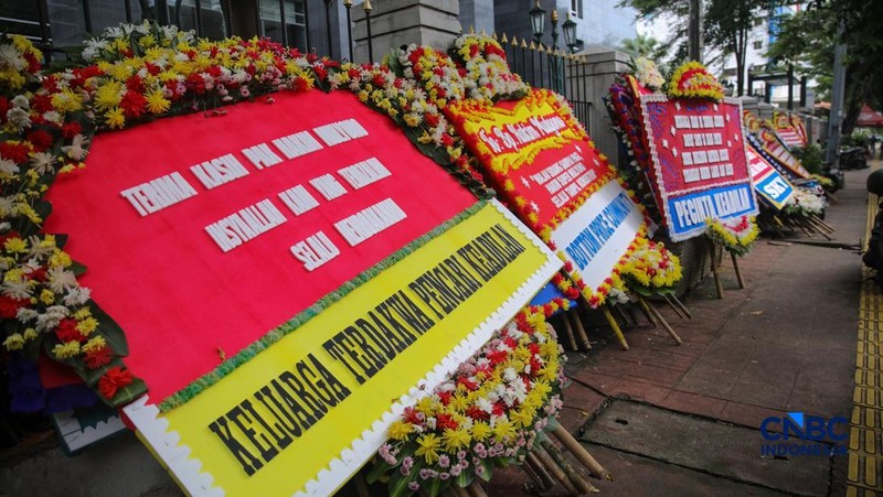 Warga berjalan di dekat deretan karangan bunga dukungan untuk Hakim anggota Mulyono di depan Pengadilan Tipikor, Jakarta, Rabu (4/3/2026). (CNBC Indonesia/Faisal Rahman)