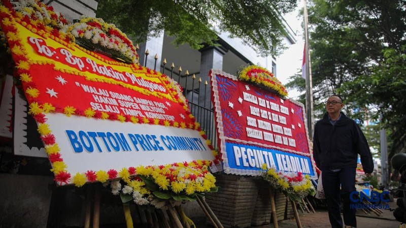 Warga berjalan di dekat deretan karangan bunga dukungan untuk Hakim anggota Mulyono di depan Pengadilan Tipikor, Jakarta, Rabu (4/3/2026). (CNBC Indonesia/Faisal Rahman)