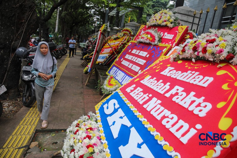 Warga berjalan di dekat deretan karangan bunga dukungan untuk Hakim anggota Mulyono di depan Pengadilan Tipikor, Jakarta, Rabu (4/3/2026). (CNBC Indonesia/Faisal Rahman)